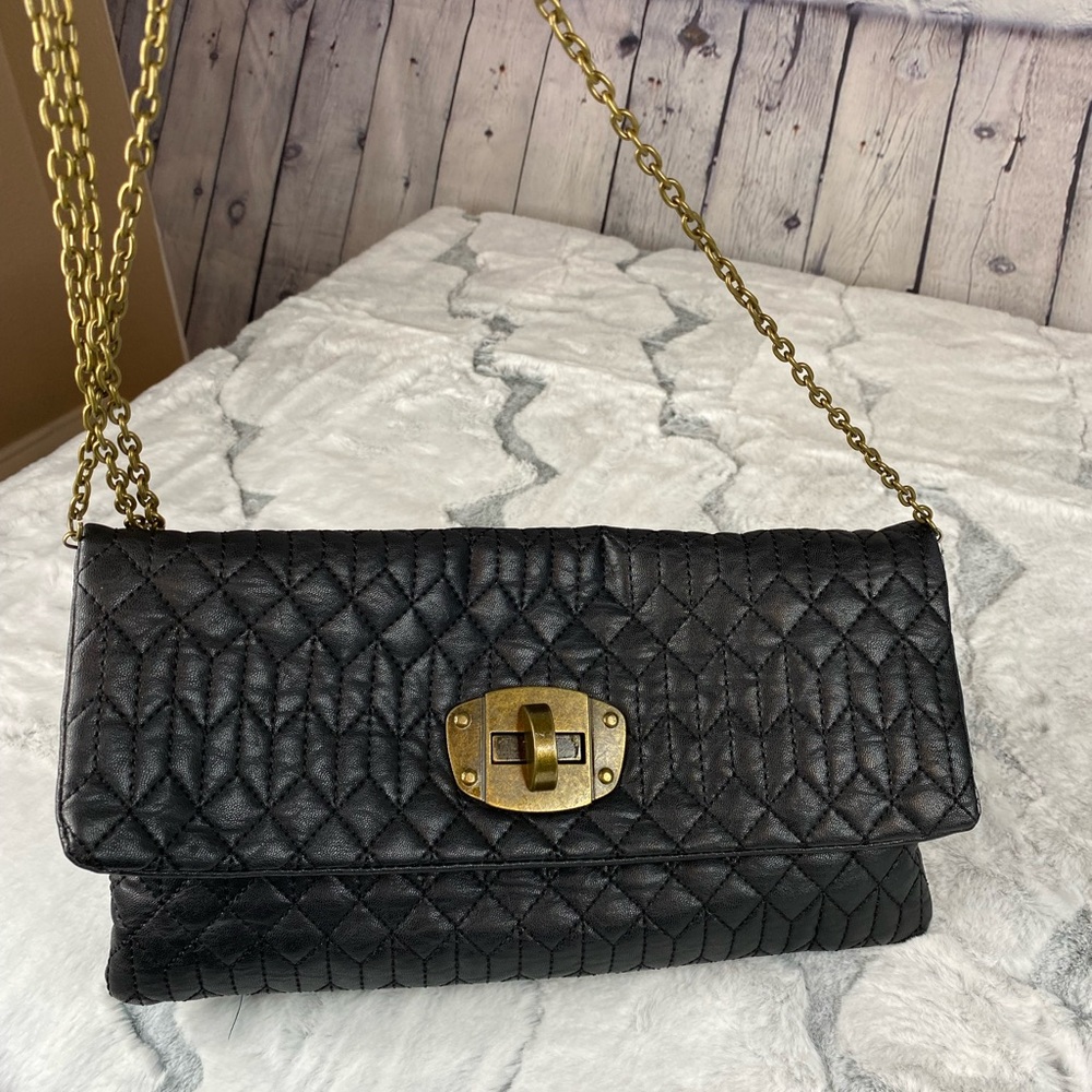 Under one sky black quilted crossbody/clutch with bronze colored metal accents!